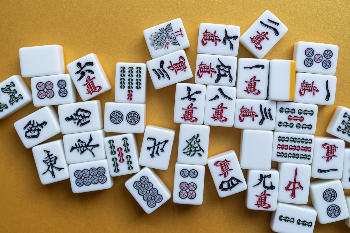 Mahjong tiles lined up on a golden background